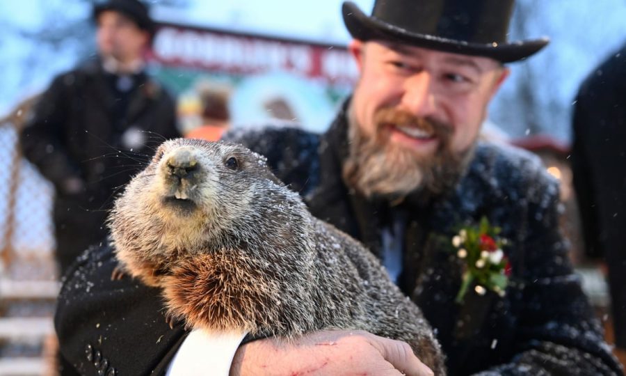 Punxsutawney Phil, held by a member of the inner circle, is adored by everyone who gathers to witness and celebrate his weather predictions for the season.