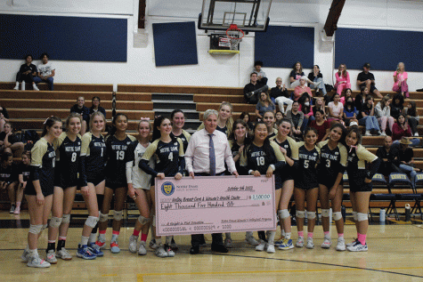 After the second set, the varsity volleyball team presents Dr. Tom Lomis of the Valley Breast Cancer and Women’s Health Center with a check for $8,500. The team will continue to raise money until they reach their fundraising goal of $20,000. 