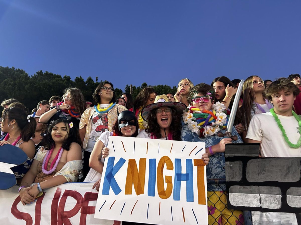 (Left to right) Seniors Caelum Goldstein, Everett Smith, and Aiden Rusche sit front row in the packed castle as they cheer on the Knights at their home opener. 
