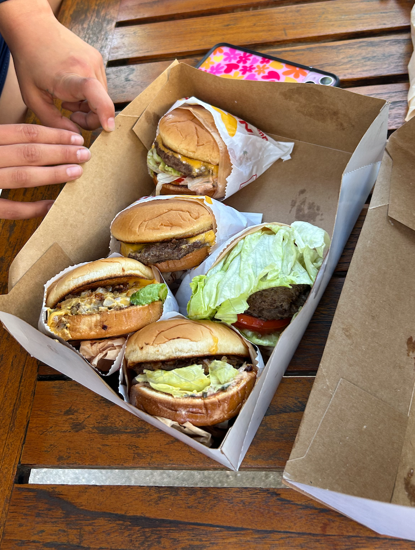 People grabbing a burger from in n out, which is a popular fast-food restaurant that many Muckbangers eat in their videos. 

