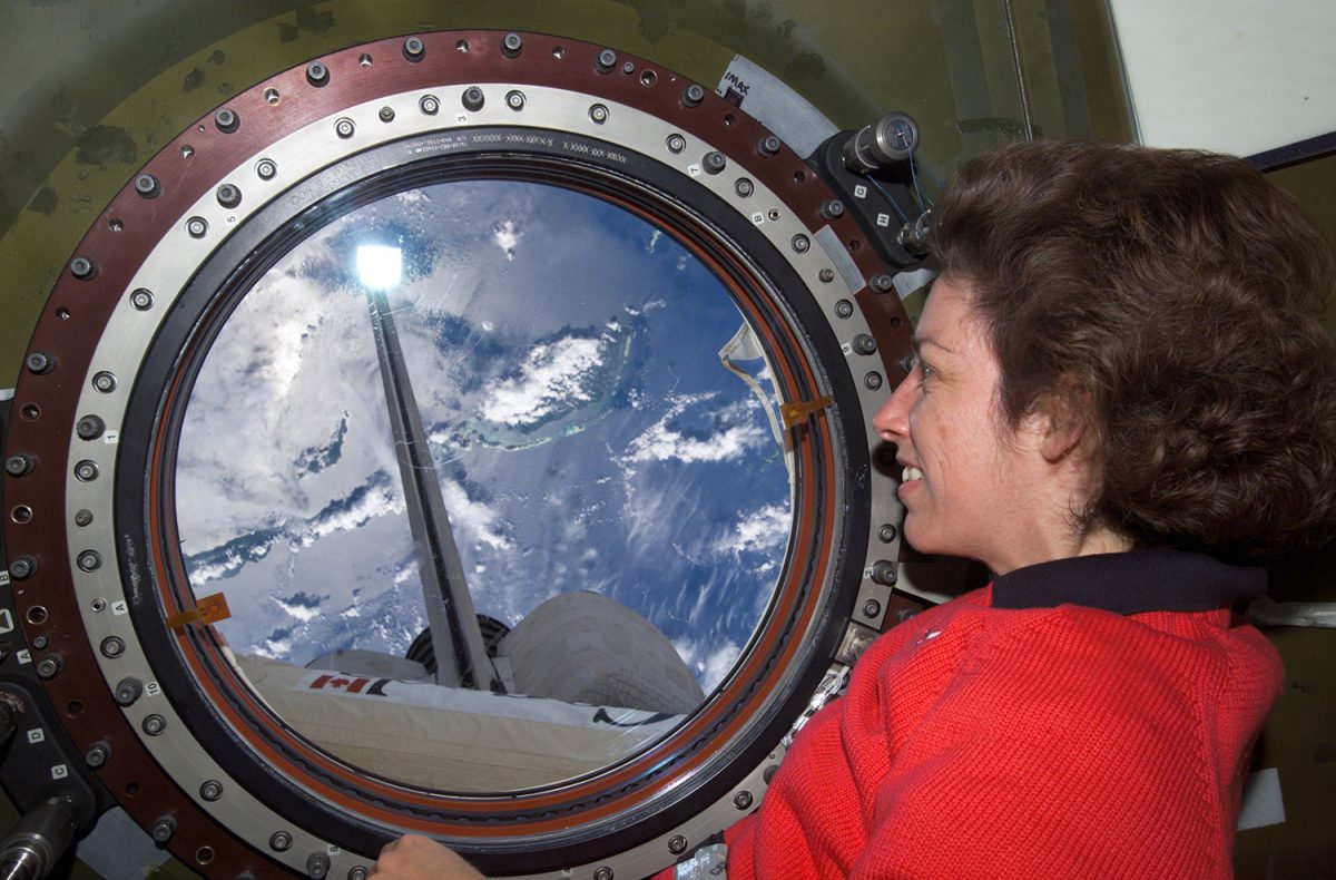 Taken on May 17, 2010, Astronaut Ellen Ochoa, STS-110 mission specialist, looks through the Earth observation window in the Destiny laboratory on the International Space Station (ISS).